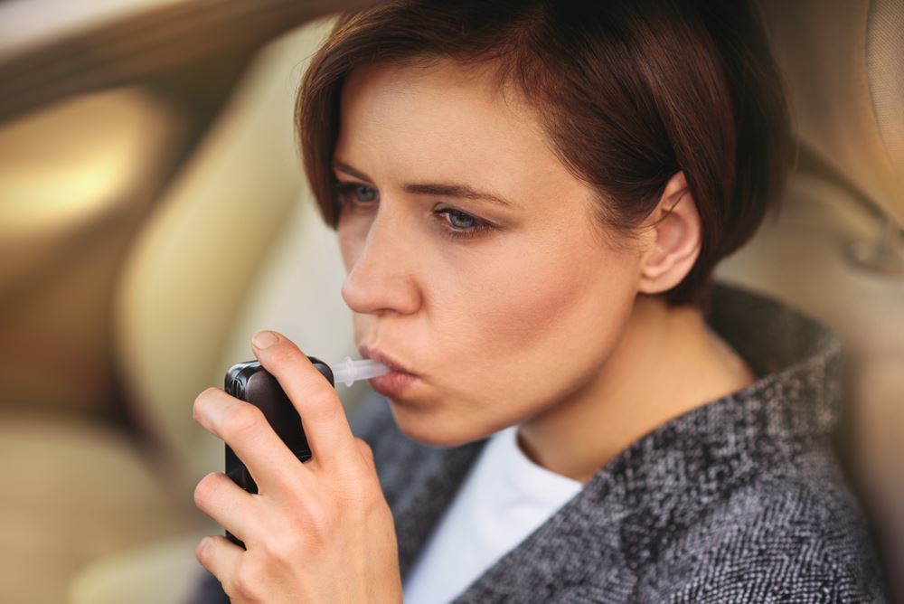 woman blowing into breathalyzer